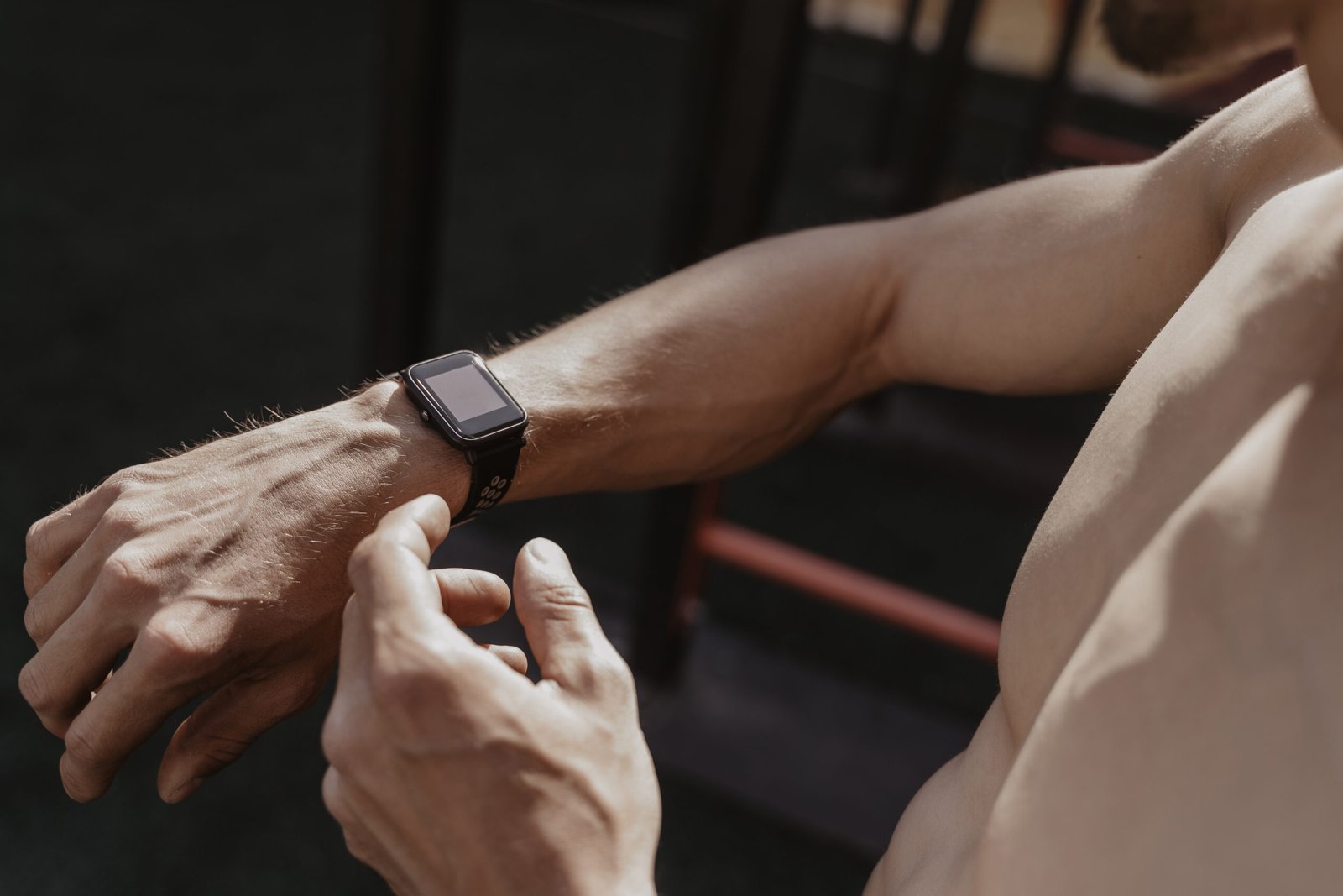 Shirtless athlete using smartwatch while resting workout. Fitness gadgets concept. Space for text. Copy space