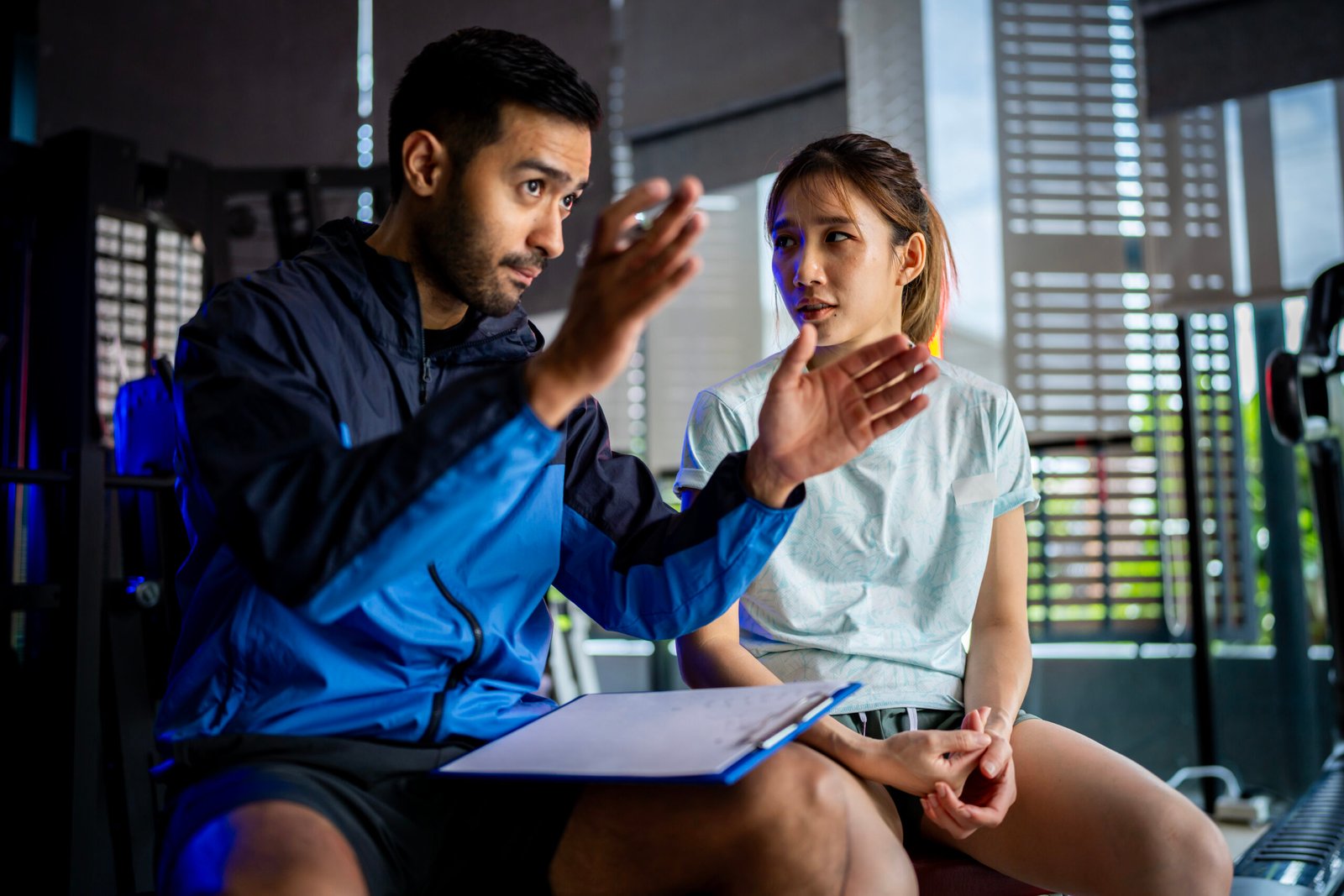 Asian man and woman working out, one is a trainer, the other is an exerciser.